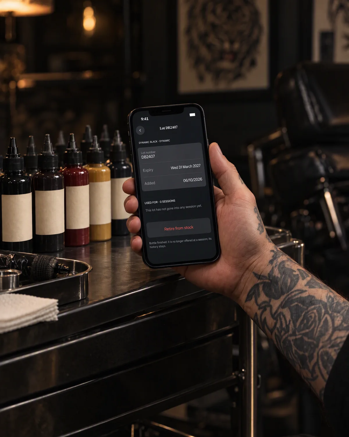 Staged photo: an ink lot in needlz, on an iPhone held in front of ink bottles