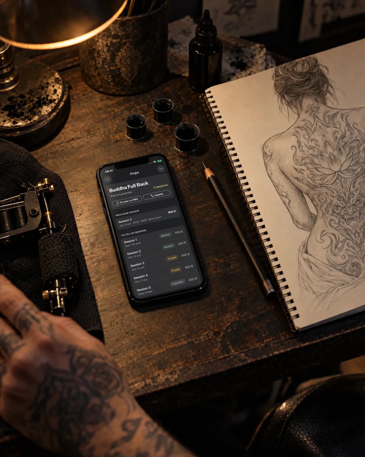 Mise en scène : un projet en plusieurs séances dans needlz, sur un iPhone posé à côté d’un croquis
